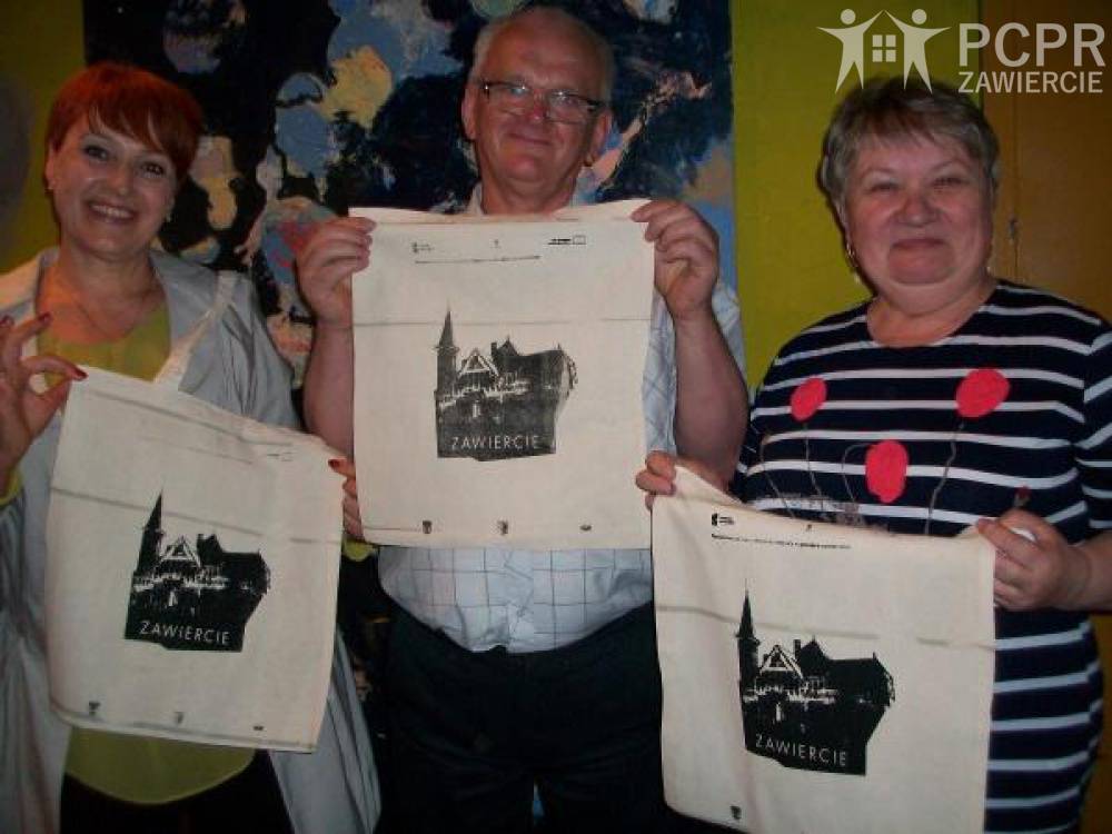Zdjęcie: Troje uczestników prezentuje lniane torby z własnoręcznie wykonanym nadrukiem w technice sitodruku